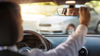 Man Adjusting A Rearview Mirror